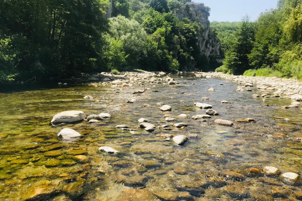 Flacher Flusslauf mit Steinen im Wasser — bequem zum Hineinwaten