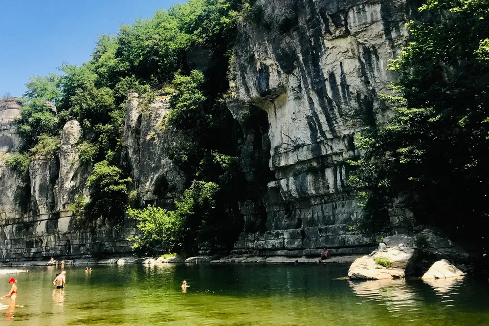 Tiefe Badegumpe unter einer hohen Kalksteinwand