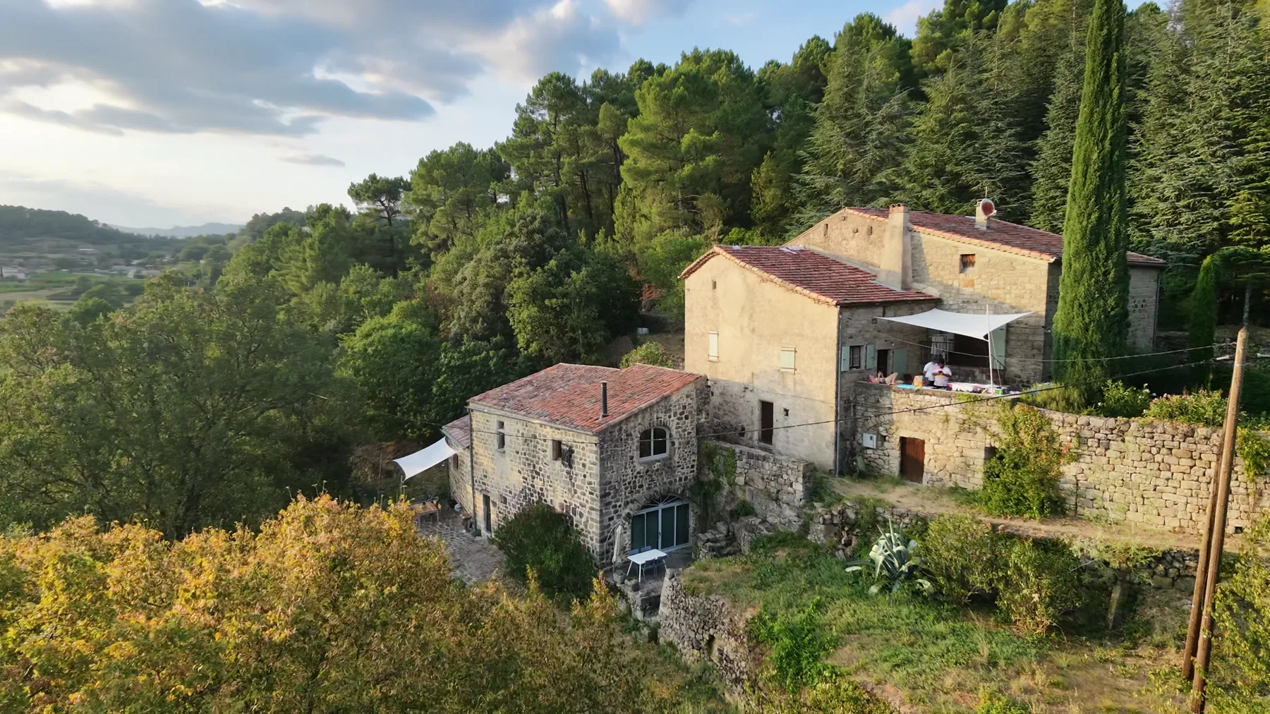 Les deux maisons en pierre dans la lumière du soir, terrasse et cyprès