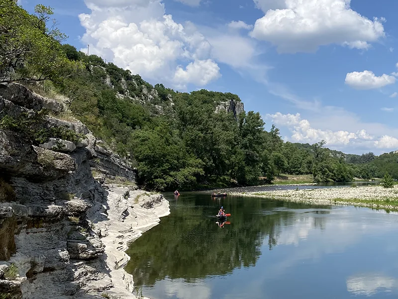 Canoë/kayak sur une rivière turquoise, falaises calcaires. Détendu, estival.